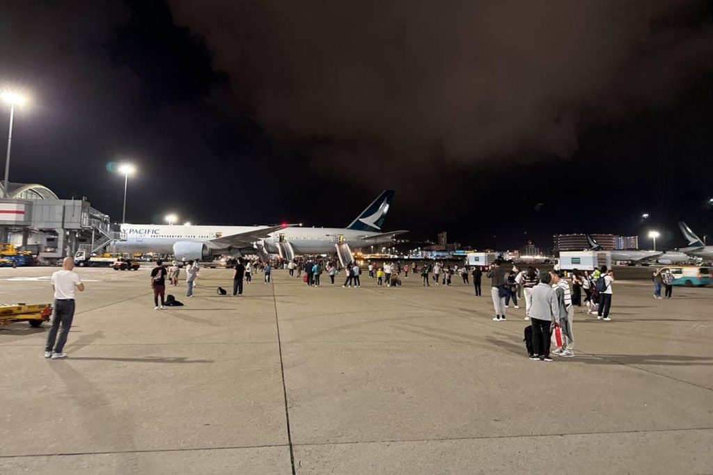 Plataforma aledaña al Boeing B777 llena de pasajeros.