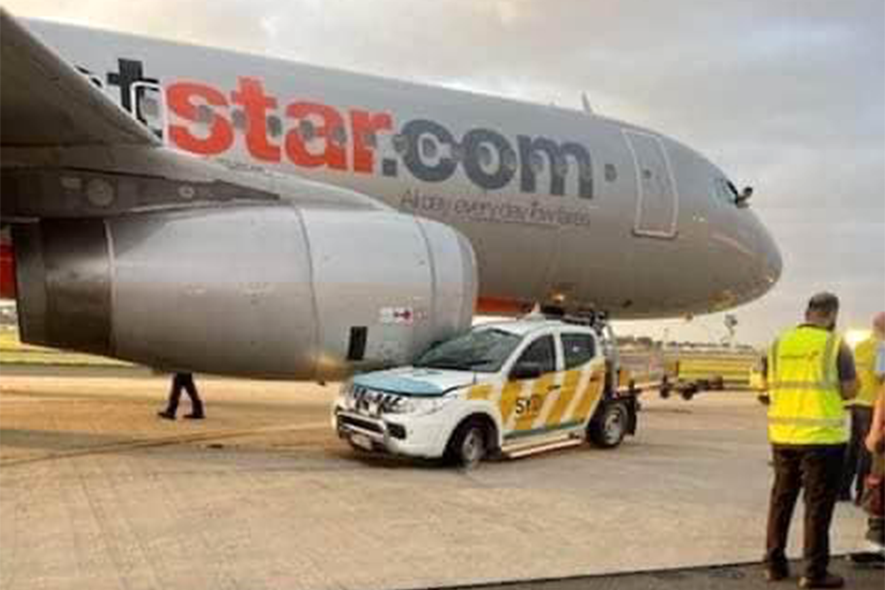 El coche quedó parcialmente incrustado bajo el motor del A320 de JetStar. Foto: desconocido / redes sociales.